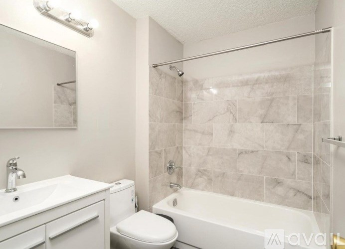 A white bathroom with a toilet, sink, and bathtub.