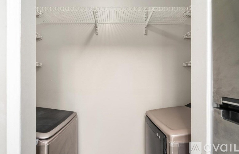 A kitchen with a white wall and a white fridge.
