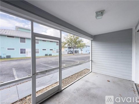 A view from inside a garage looking out to a parking lot and buildings.