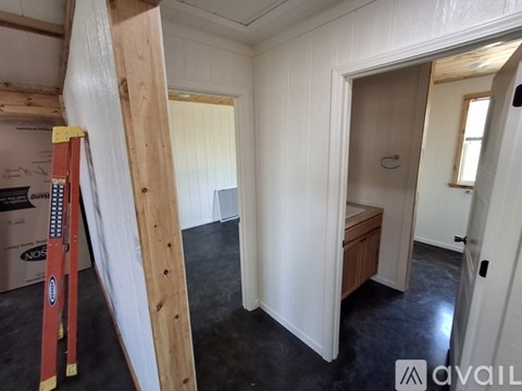 A room under construction with a ladder and a box labeled "NOS" on the floor.