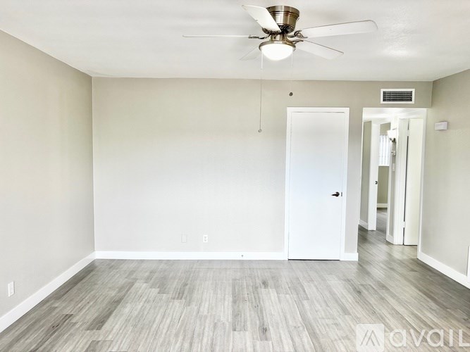 A room with a ceiling fan and a door.