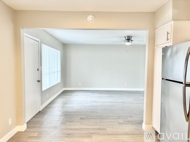 A kitchen with a refrigerator on the right side.