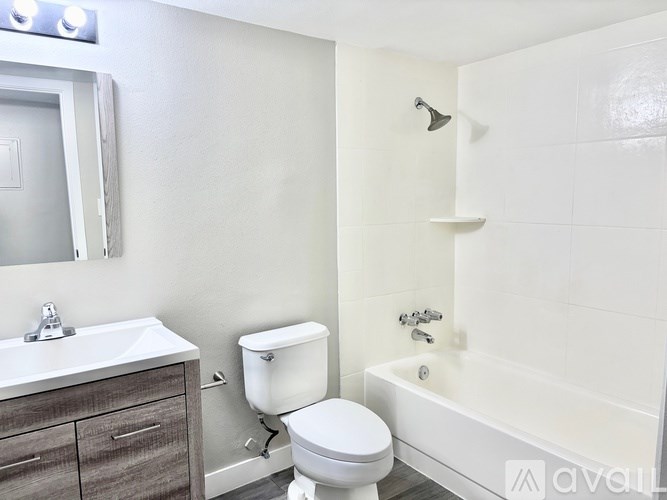 A white toilet sits next to a white sink in a bathroom.