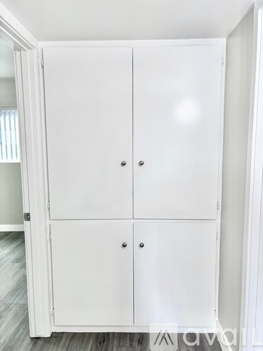 A white double door cabinet with two handles is open.
