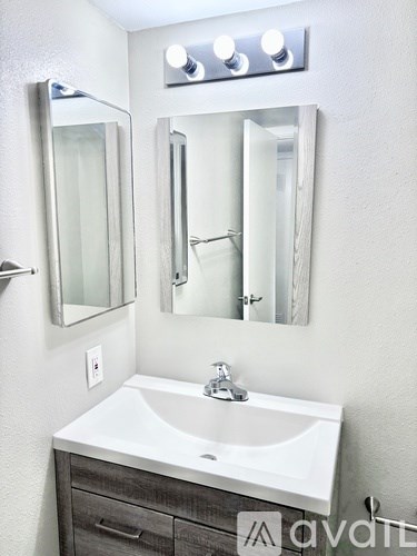 A white sink in a bathroom with a mirror above it.
