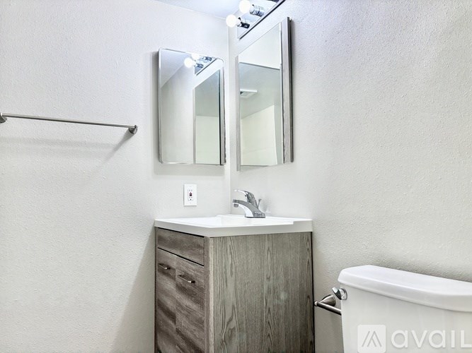A bathroom with a white sink and a wooden cabinet.