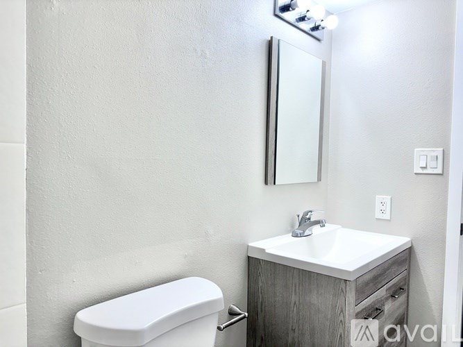 A white toilet sits next to a sink in a bathroom.