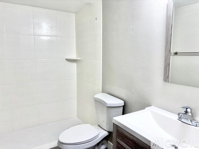 A white toilet sits next to a white sink in a small bathroom.