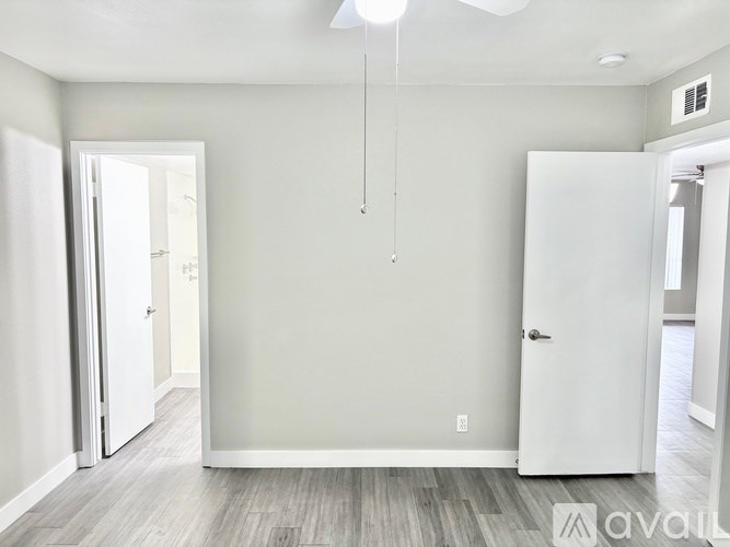 A room with a white door and a grey wall.