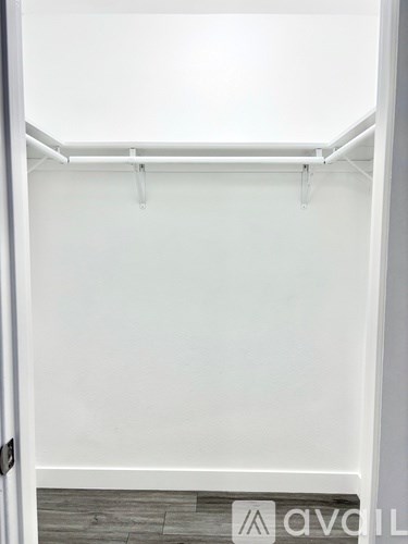 A white closet with a hanging rod and a door.