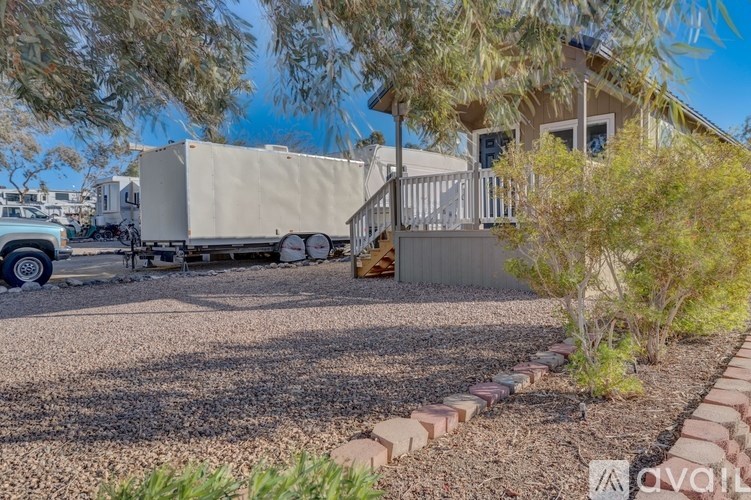 A white trailer is parked in a driveway next to a house.