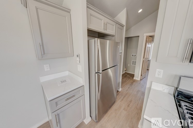 A kitchen with a stainless steel refrigerator and white appliances.