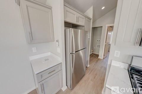 A kitchen with a stainless steel refrigerator and white appliances.