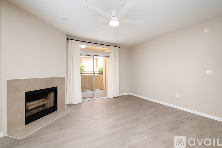 A spacious room with a fireplace and a ceiling fan.