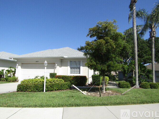 A house with a white garage door and a white house number sign.