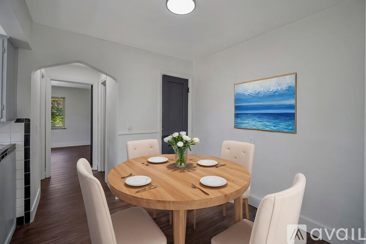 A dining room with a wooden table set for four.