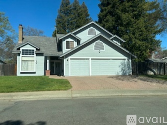 A house with a grey roof and a brown garage door.