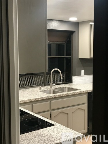 A kitchen with a sink and a stove top.