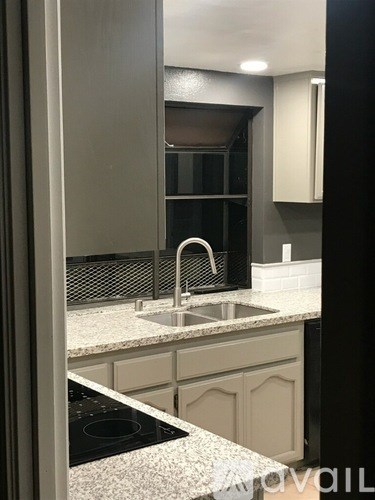 A kitchen with a sink and a stove top.