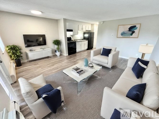 A living room with white furniture and a flat screen TV.
