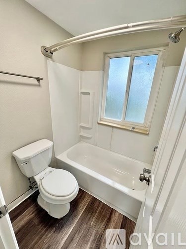 A white toilet sits next to a bathtub in a bathroom.
