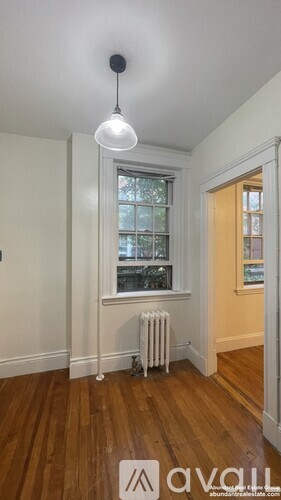 A room with a window and a radiator on the floor.