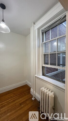 A room with a window and a radiator on the floor.