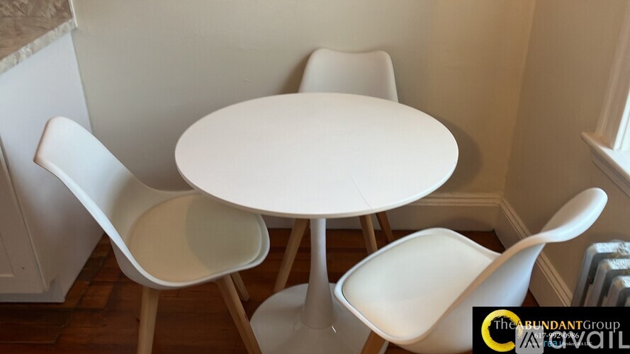 A white table and chairs are set up in a room.