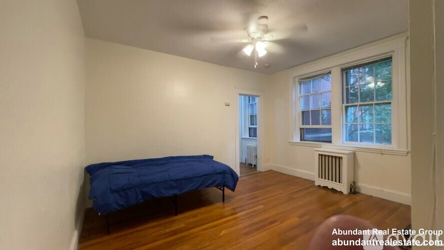 A bedroom with a bed and a window.