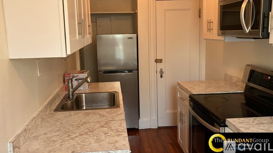 A kitchen with a sink and a refrigerator.
