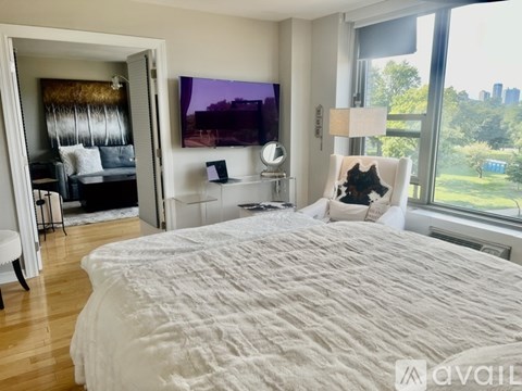 A bedroom with a large bed and a flat screen TV mounted on the wall.