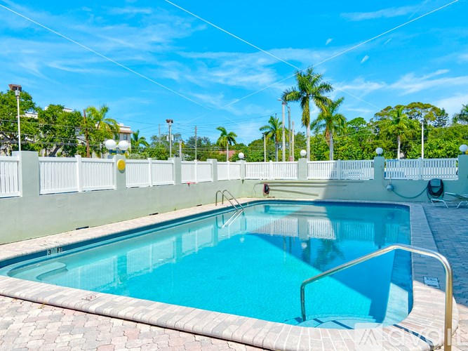 A small pool surrounded by a white fence.