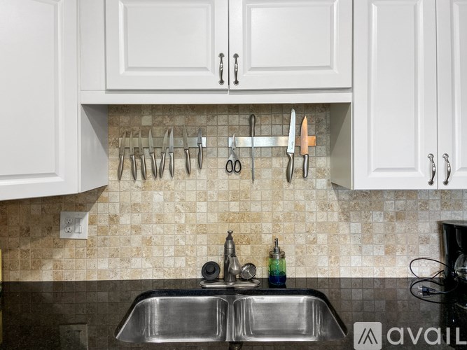 A kitchen with white cabinets and a tile backsplash.