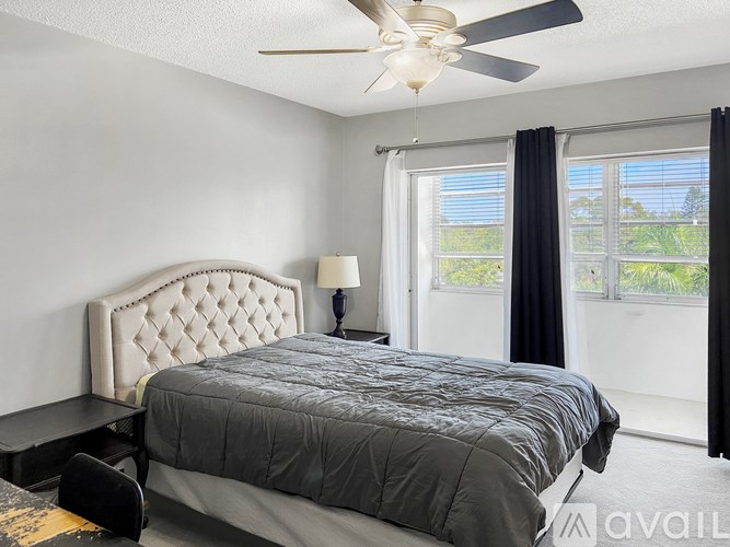 A bedroom with a large bed and a ceiling fan.