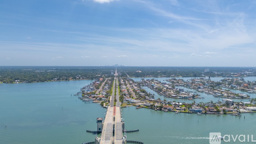A long bridge spans a body of water with a city in the background.