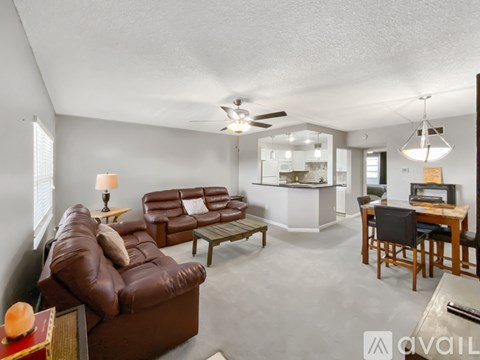A living room with a brown leather couch and a wooden table.