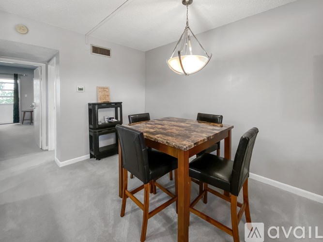 A dining room with a wooden table and chairs.