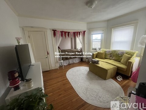 A living room with a yellow couch and a television.
