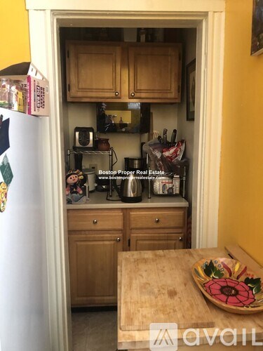 A kitchen with wooden cabinets and a white refrigerator.