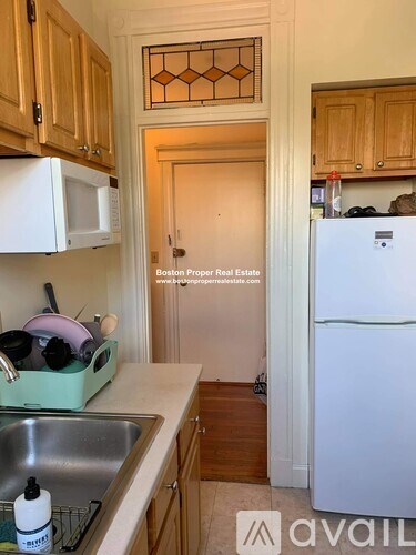 A kitchen with wooden cabinets and a white fridge.