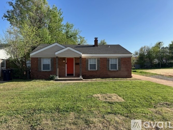 A small brick house with a red door and a chimney.