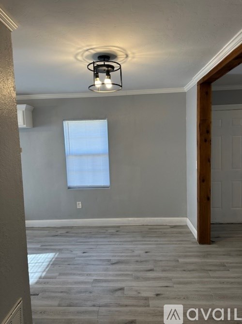 A room with a ceiling light and a window with blinds.