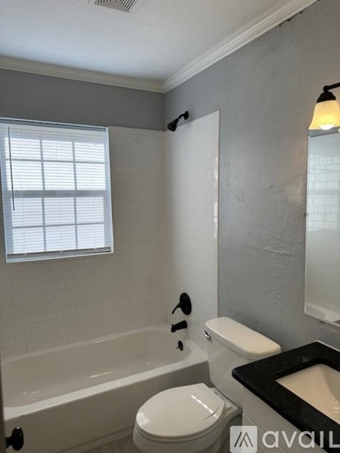 A bathroom with a white toilet and a bathtub.