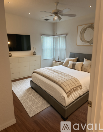 A bedroom with a large bed and a television on the wall.