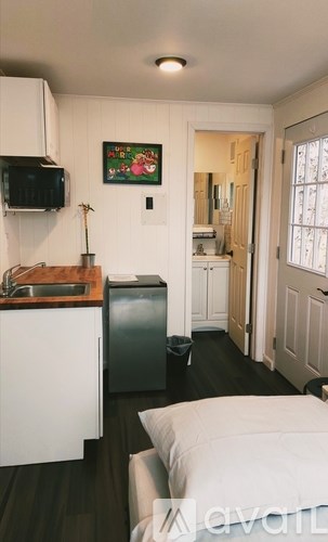 A kitchen with white cabinets and a black fridge.