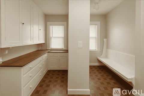 A kitchen with white cabinets and a wooden countertop.