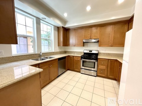 A kitchen with wooden cabinets and a stainless steel dishwasher.