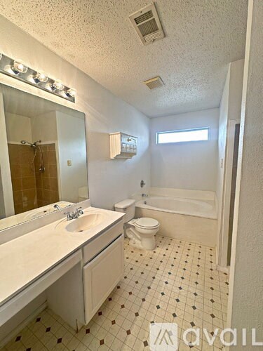 A bathroom with a toilet, sink, and bathtub.