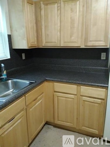 A kitchen with wooden cabinets and a granite countertop.