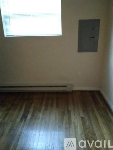 A room with wooden flooring and a window.